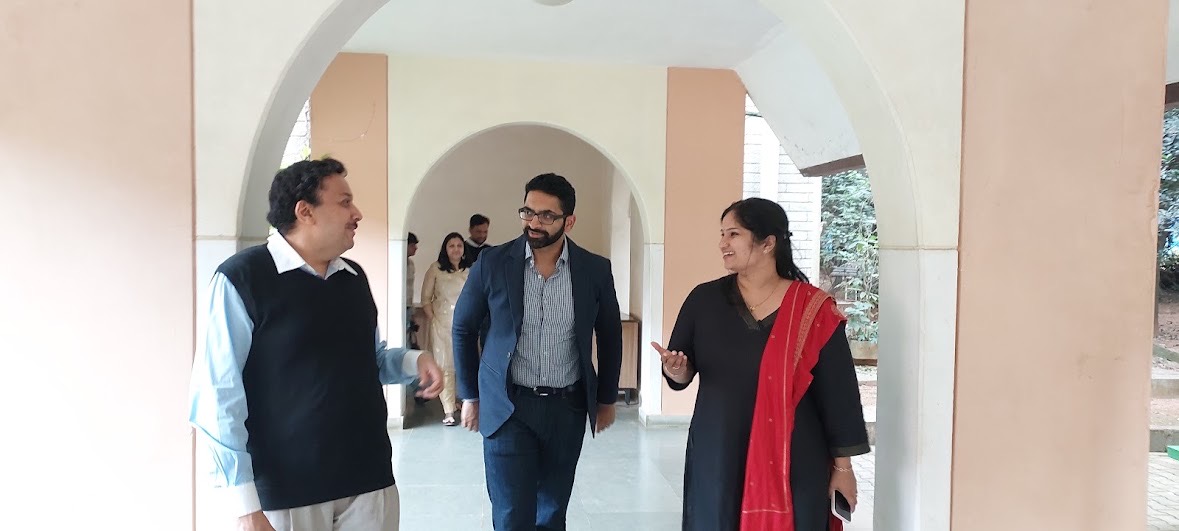Participants walking and talking beneath an arched corridor at the National Institute of Advanced Studies